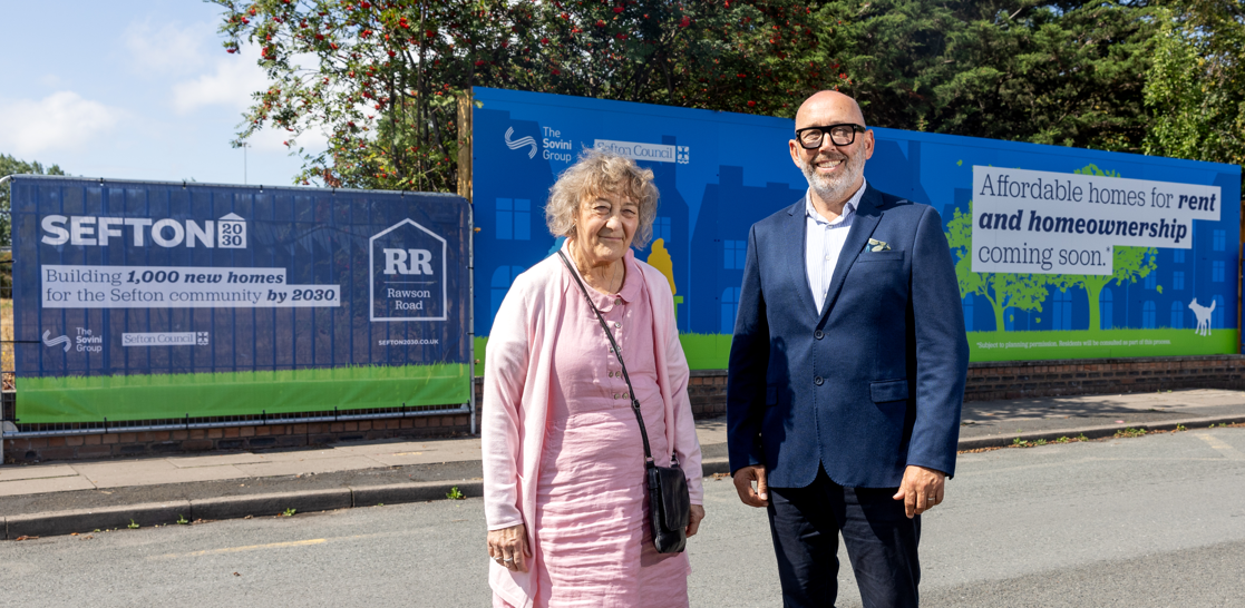 Two people stand on a residential street in front of large Sefton 2030 and Rawson Road development hoardings. The signs promote plans to build 1,000 new homes by 2030 and advertise affordable homes for rent and homeownership. The image accompanies the headline: “Sefton 2030 partnership to create skills and employment opportunities for local people.”