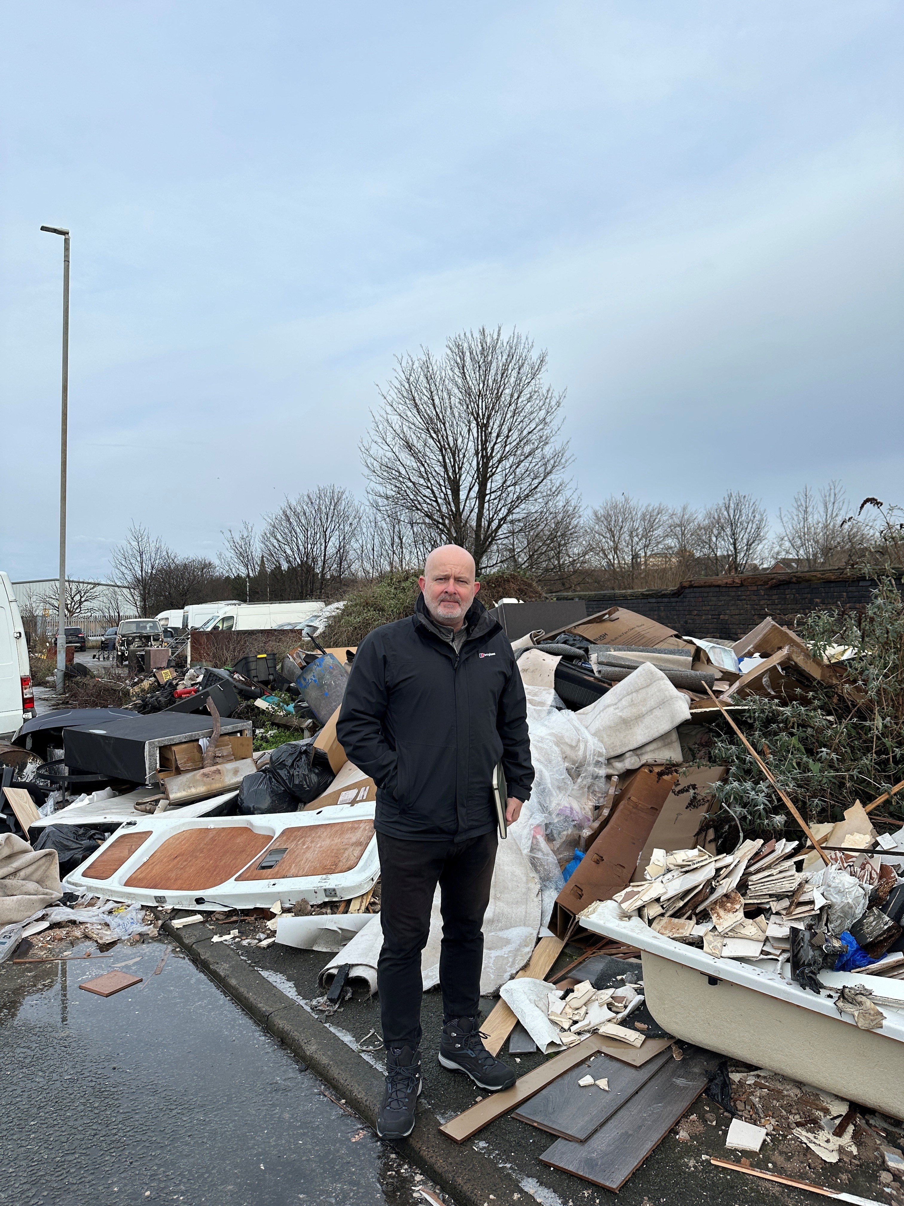 Cllr Peter Harvey, Cabinet Member for Street Scene and Cleansing in front of fly-tipped rubbish