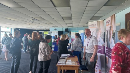 People stood around a room, which has stalls from a number of organisations in Sefton that provide support for families and young people.