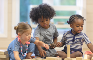 three children playing with wooden toys