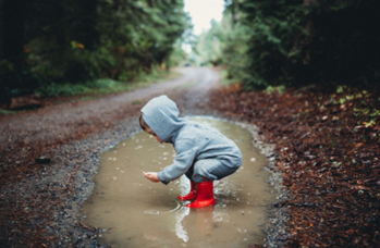 child playing in puddle