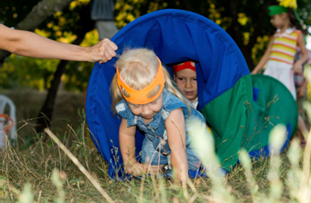 child crawling through toy tunnel