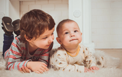 toddler and baby sitting next to each other