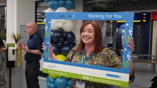 Cllr Howard holding a SeftonatWork banner