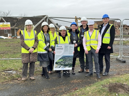 The Sandbrook coproduction group stood on the development site in high-vis and hard hats.