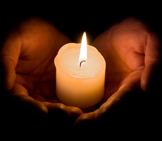 Hands holding a candle 