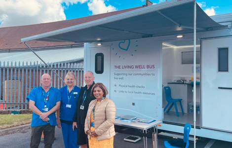 Living Well Bus team standing in front of the  vehicle