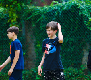 Three smiling young people in an outdoor setting. 