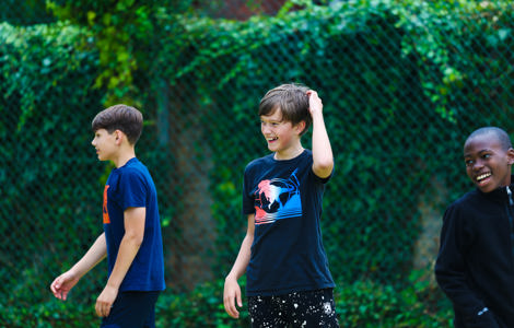 Three smiling young people in an outdoor setting. 